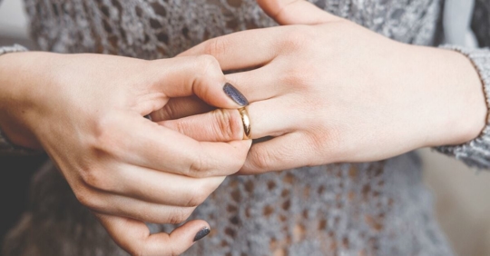 woman taking off wedding ring